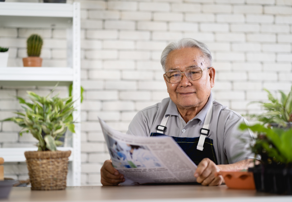 man holding a magazine surrounded by plants