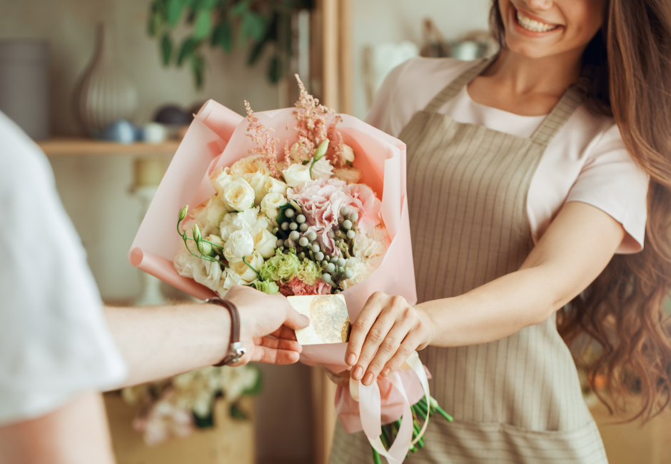 florist handing flowers and receiving credit card
