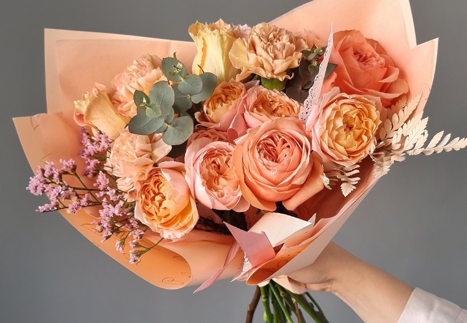 orange and pink wrapped bouquet of flowers