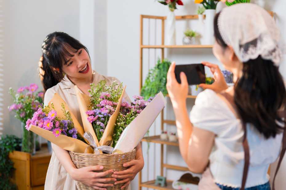 One Arrangement, Multiple Posts! 1 woman taking a photo of another woman with flower bouquets